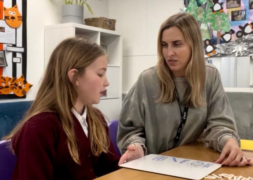 Rosie working one-to-one with a pupil at a table